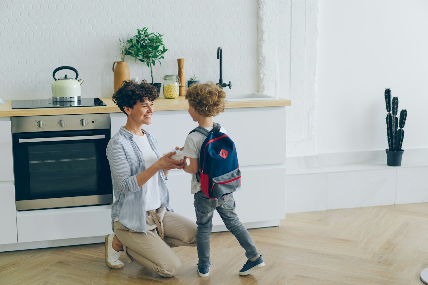 Mãe e filho conversando numa cozinha clara de casa